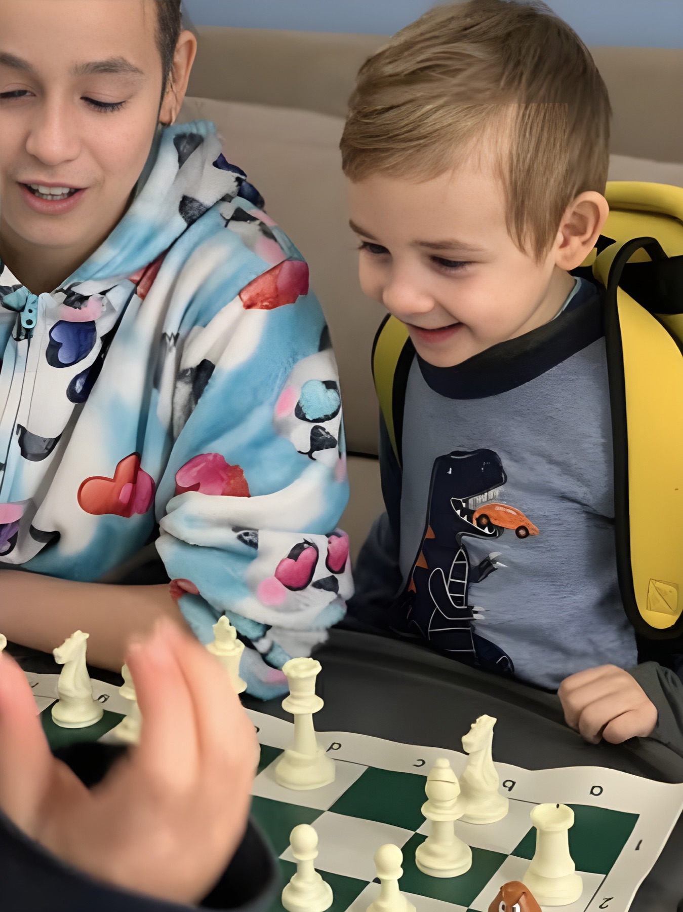 Kids smiling over a chessboard